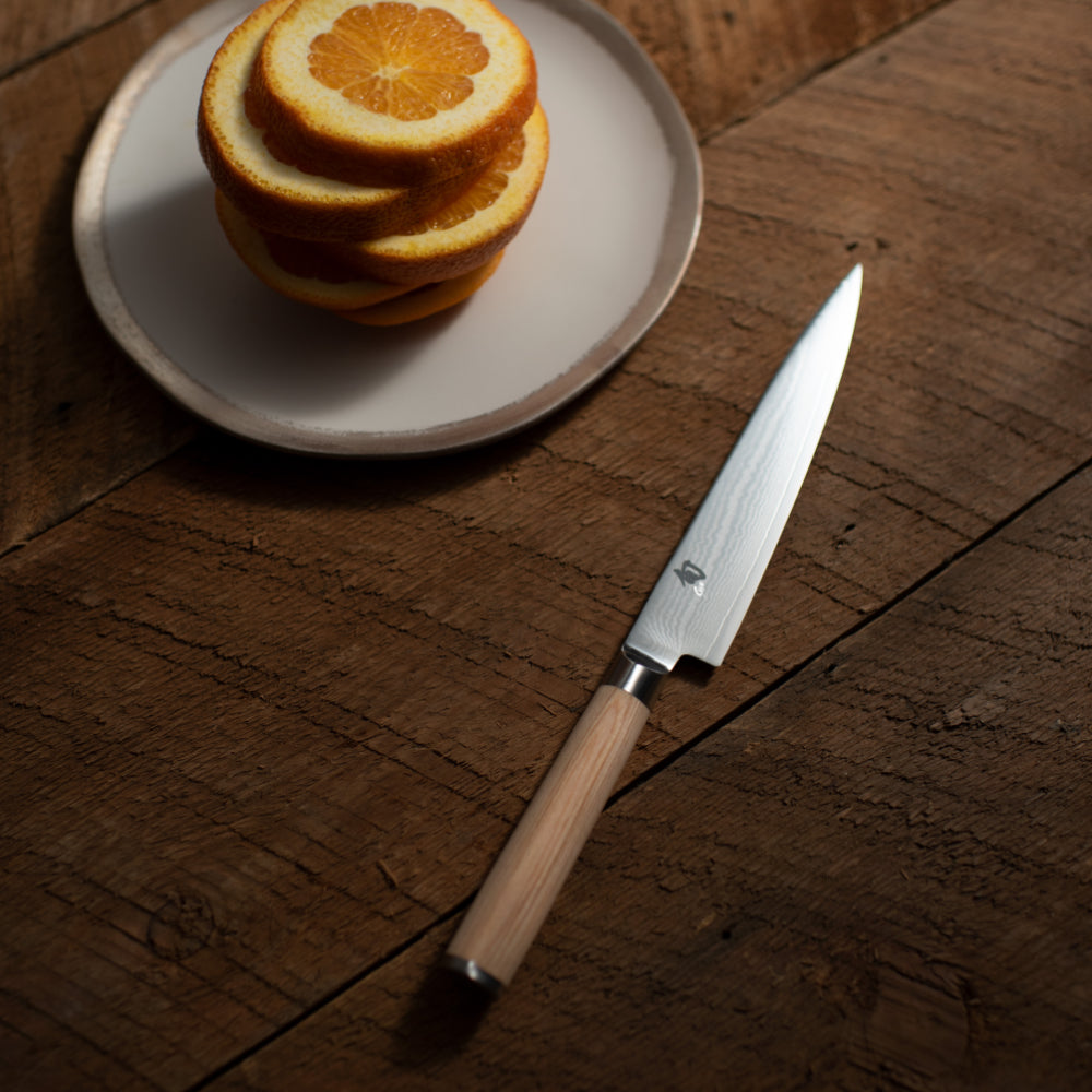 Shun Classic Blonde 6" Utility Knife in Use Slicing an Orange with Ease