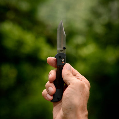 Buck 110 Folding Hunter Crossbar Knife in Hand Outdoors