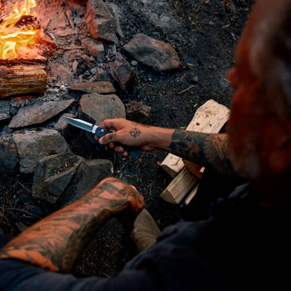 Buck 110 Folding Hunter Crossbar Knife by the Campfire in Hand
