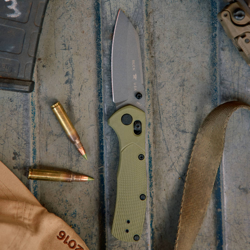 Buck 797 Range Pro Ops Lockblade Knife Green Fully Open in Pickup Bed with Other Hunting Gear