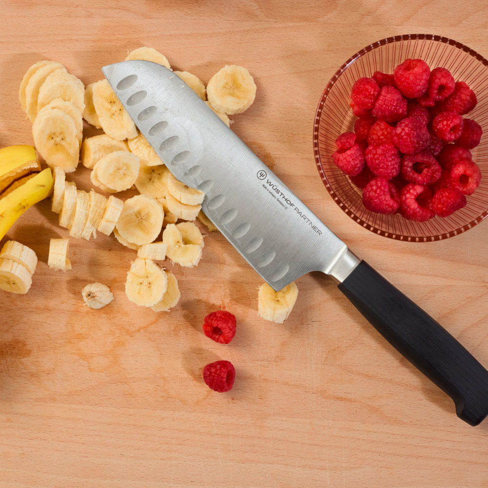 Wusthof Partner 7" Hollow Edge Santoku Knife in Use Slicing Bananas